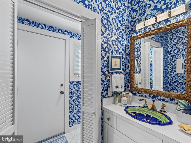 bathroom with vanity and wallpapered walls