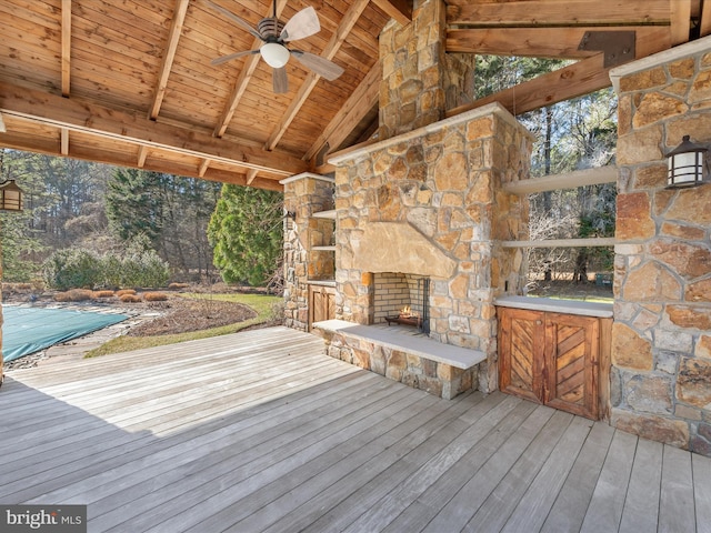 wooden terrace with an outdoor stone fireplace