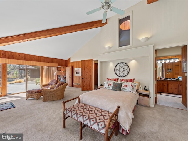 carpeted bedroom with beam ceiling, high vaulted ceiling, access to outside, connected bathroom, and wooden walls