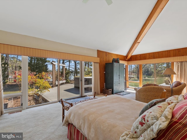 bedroom featuring a sunroom, wooden walls, carpet floors, and access to outside