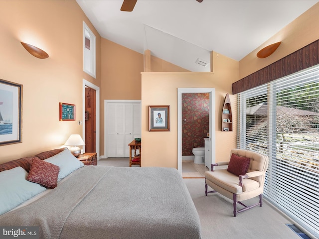 bedroom featuring visible vents, high vaulted ceiling, ensuite bath, a closet, and light carpet