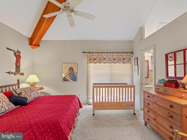 carpeted bedroom with connected bathroom, vaulted ceiling with beams, and a ceiling fan