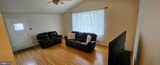 living area with lofted ceiling, baseboards, ceiling fan, and light wood finished floors