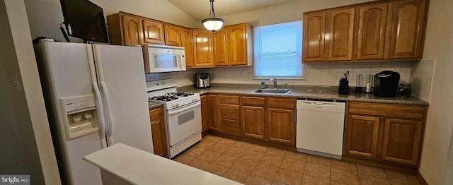 kitchen with white appliances, a sink, vaulted ceiling, decorative backsplash, and brown cabinetry