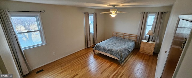 bedroom with a ceiling fan, visible vents, and light wood-style floors