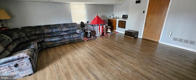 living area featuring visible vents and wood finished floors