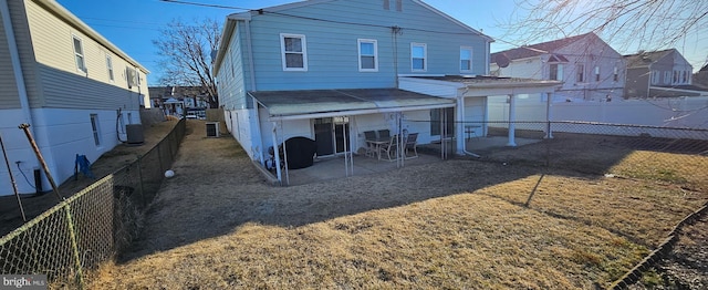 rear view of property featuring a patio, central AC unit, and a fenced backyard