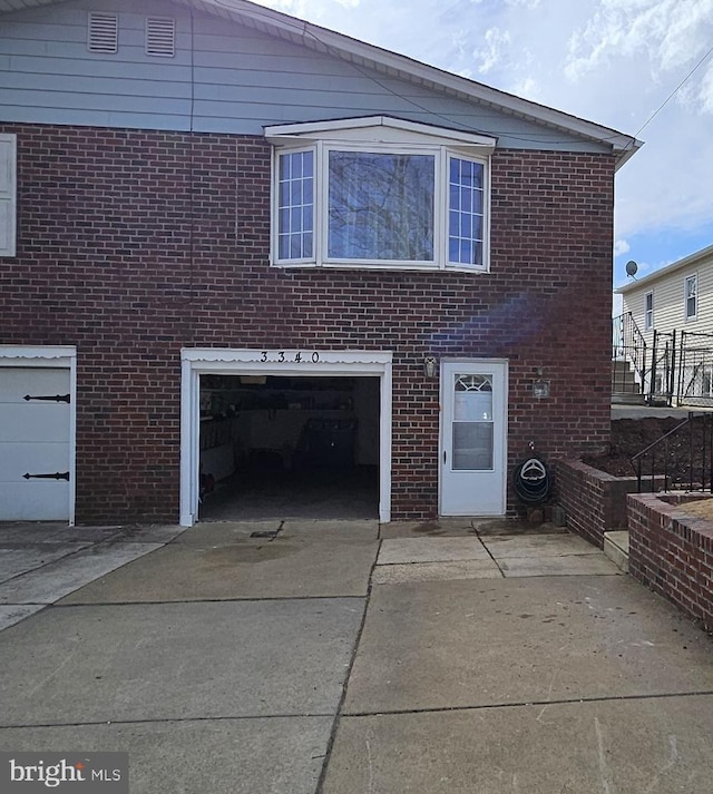 view of front facade featuring a garage, concrete driveway, and brick siding