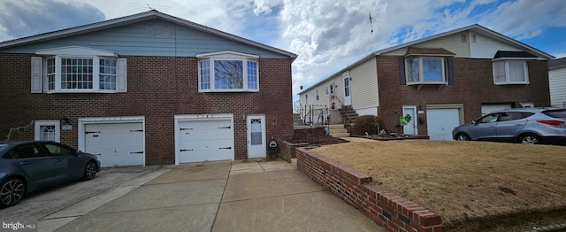 view of front of property with a front yard, brick siding, driveway, and an attached garage