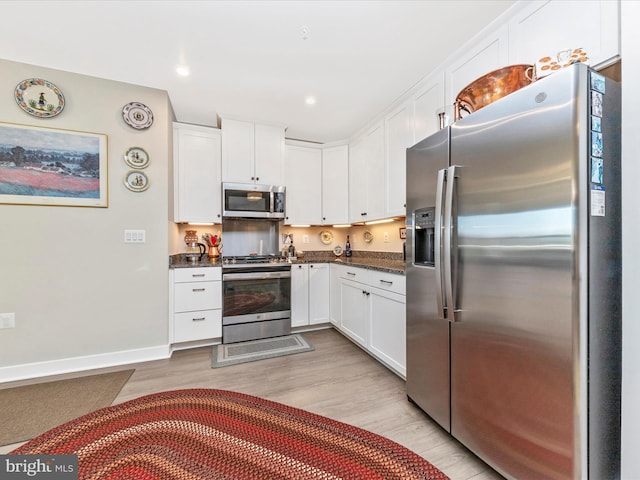 kitchen featuring baseboards, recessed lighting, light wood-style floors, appliances with stainless steel finishes, and white cabinetry