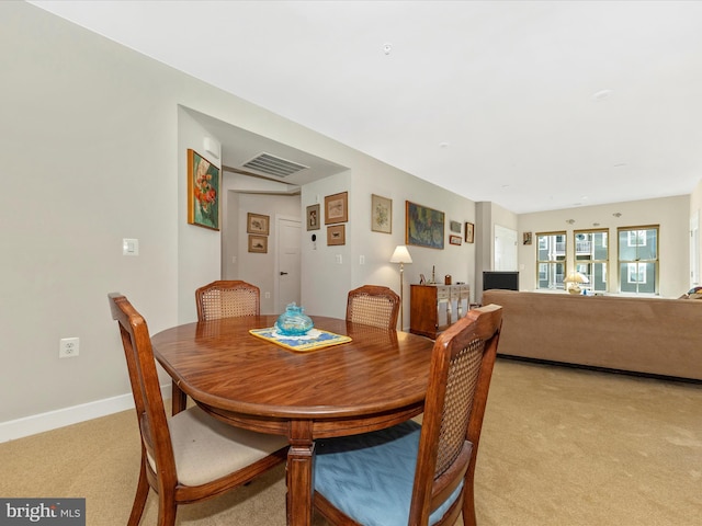 dining area featuring light carpet, visible vents, and baseboards