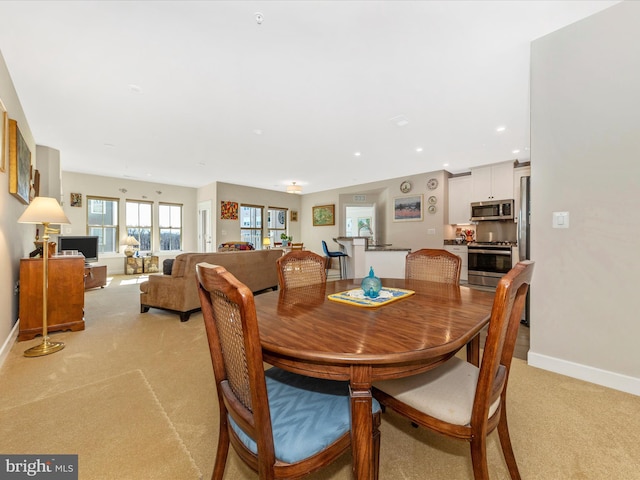 dining room featuring recessed lighting, baseboards, and light carpet