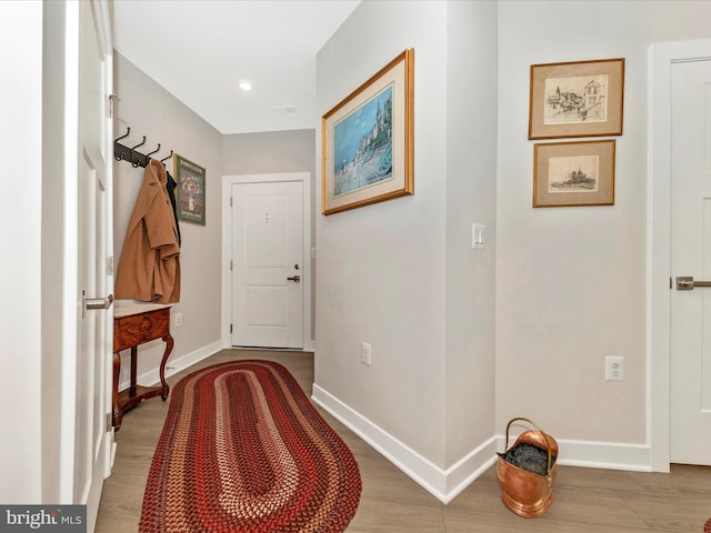 hallway featuring recessed lighting, wood finished floors, and baseboards