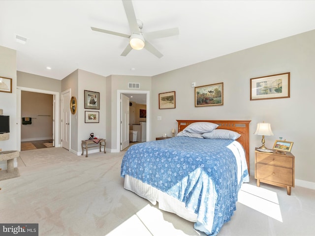 carpeted bedroom featuring visible vents, ceiling fan, ensuite bathroom, and baseboards