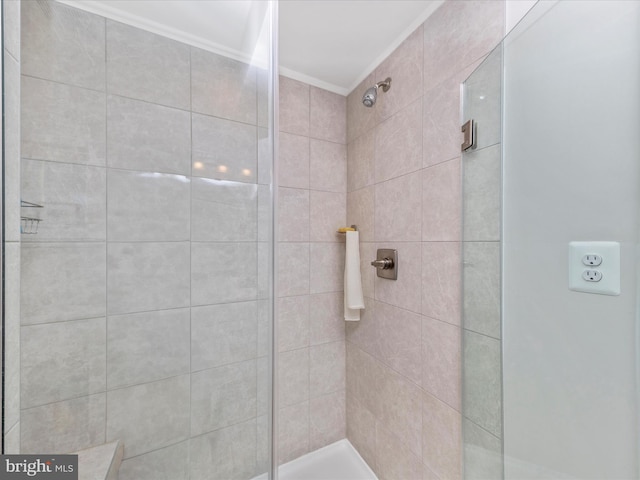 bathroom with tiled shower and crown molding