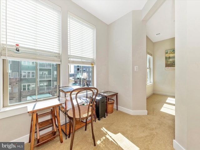 carpeted dining room featuring a wealth of natural light, visible vents, and baseboards