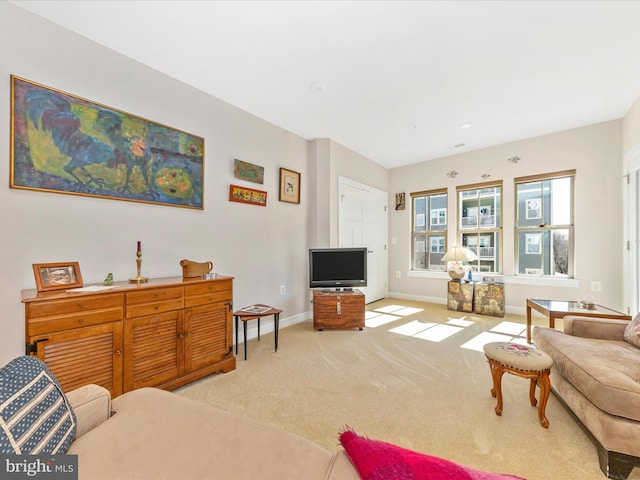 carpeted living area featuring baseboards