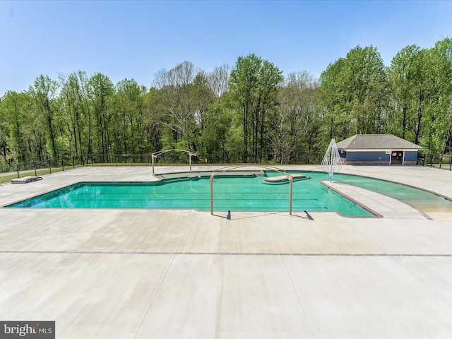 outdoor pool with a patio area and fence