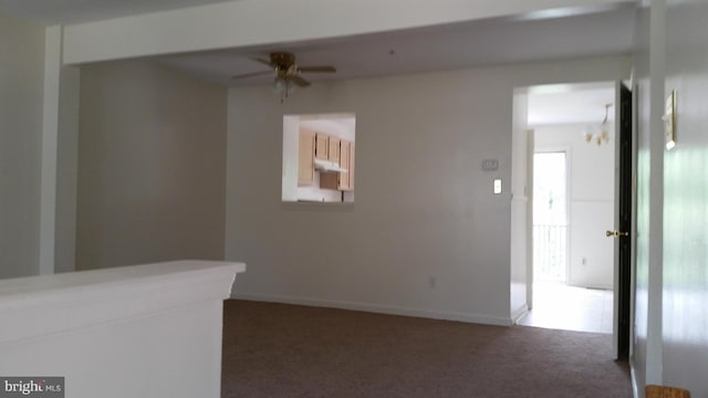 carpeted empty room with a ceiling fan and baseboards