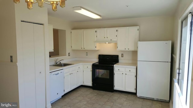 kitchen with white appliances, white cabinetry, a sink, and under cabinet range hood