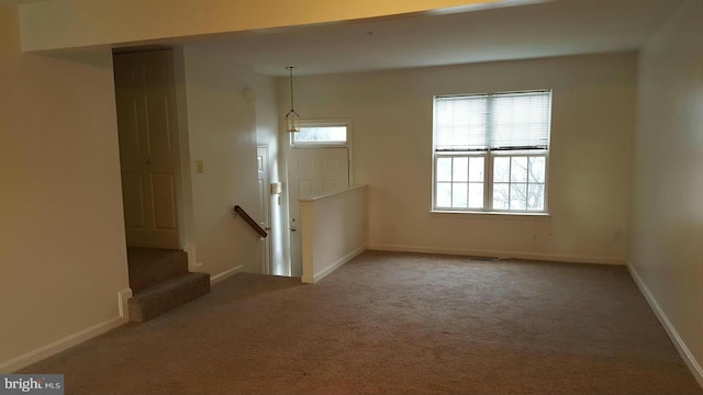 empty room featuring baseboards, a healthy amount of sunlight, and carpet flooring