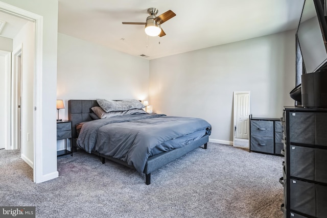 carpeted bedroom with visible vents, baseboards, and ceiling fan