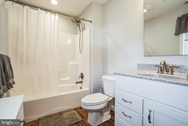 bathroom with visible vents, toilet, wood finished floors, shower / bath combo with shower curtain, and vanity