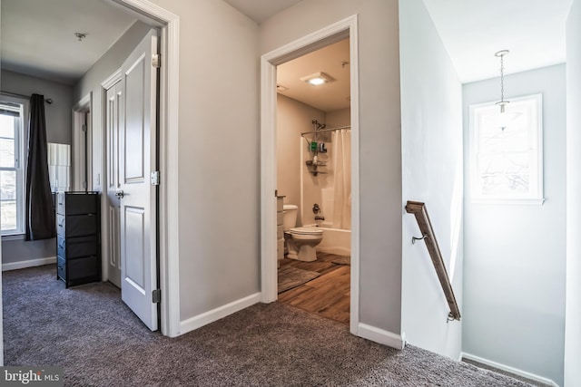 hallway with carpet, baseboards, and an upstairs landing