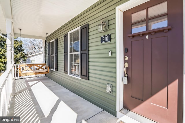 view of exterior entry featuring covered porch