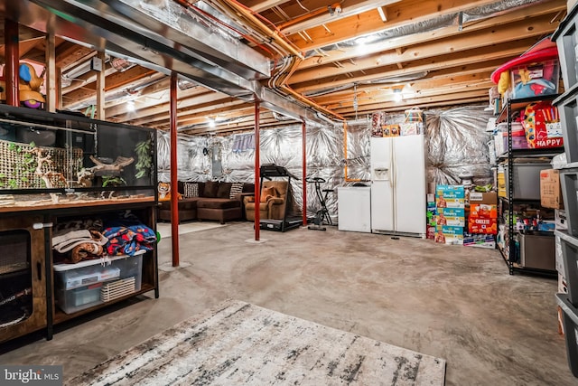 unfinished below grade area featuring white refrigerator with ice dispenser and fridge