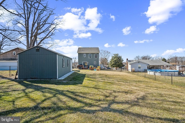 view of yard featuring fence, a fenced in pool, and an outdoor structure