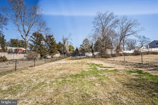 view of yard with a trampoline and a fenced backyard