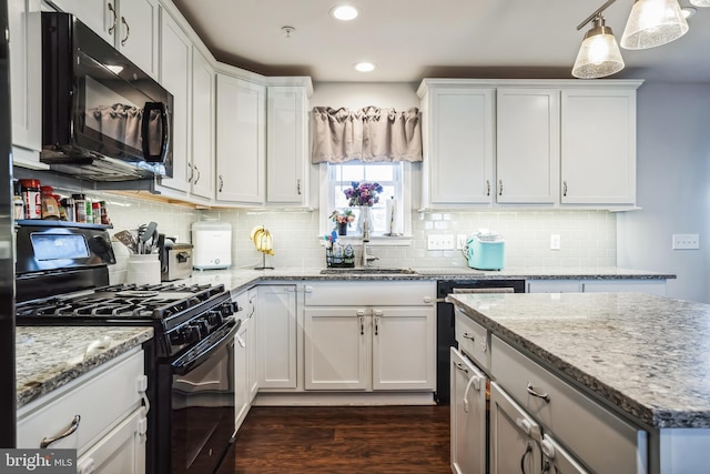 kitchen featuring black appliances, tasteful backsplash, white cabinetry, and a sink