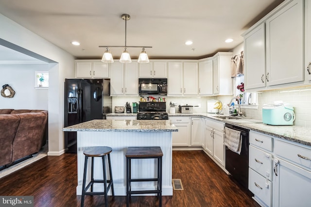 kitchen with dark wood-style floors, white cabinets, and black appliances