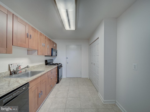 kitchen with light tile patterned floors, a sink, baseboards, light countertops, and black appliances