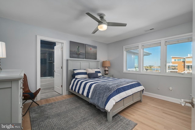 bedroom with a ceiling fan, visible vents, baseboards, light wood finished floors, and ensuite bath