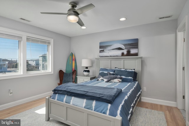 bedroom with baseboards, visible vents, and light wood finished floors