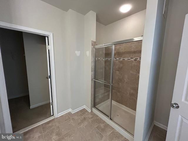 full bathroom with a stall shower and baseboards