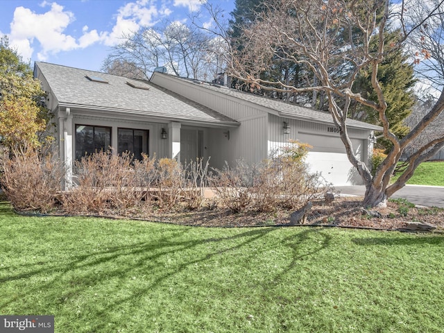 view of front of home featuring a front lawn, roof with shingles, and an attached garage