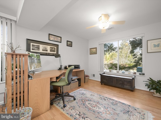 office space with a ceiling fan, wood finished floors, visible vents, and radiator