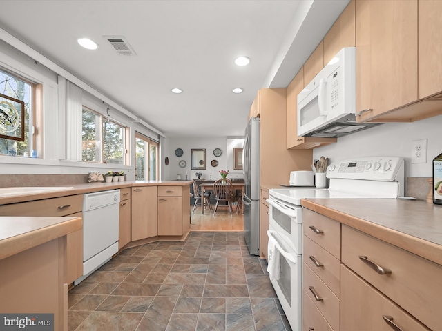 kitchen featuring white appliances, visible vents, light countertops, light brown cabinets, and recessed lighting