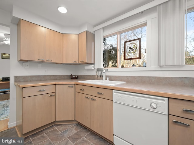 kitchen with a sink, light brown cabinets, light countertops, and dishwasher