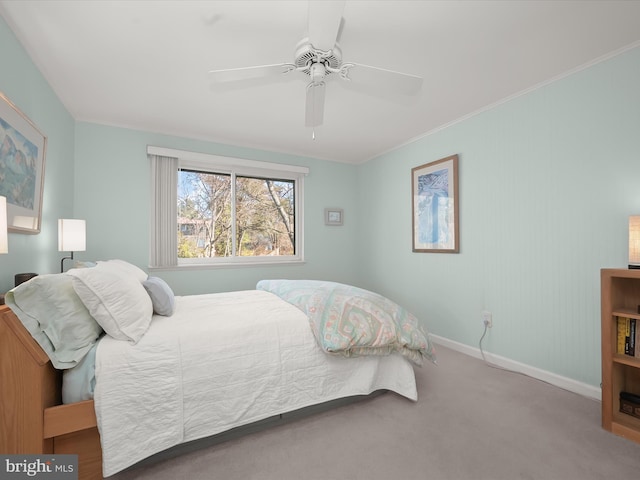 carpeted bedroom featuring crown molding, baseboards, and a ceiling fan