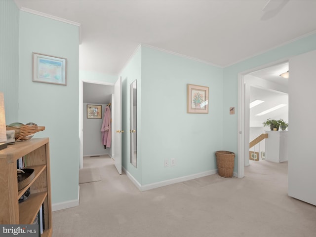 corridor featuring baseboards, carpet, an upstairs landing, and crown molding