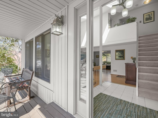 wooden terrace featuring covered porch and visible vents