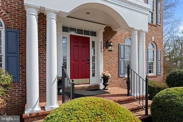 entrance to property featuring brick siding