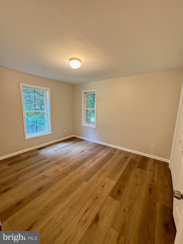 empty room featuring wood finished floors and baseboards