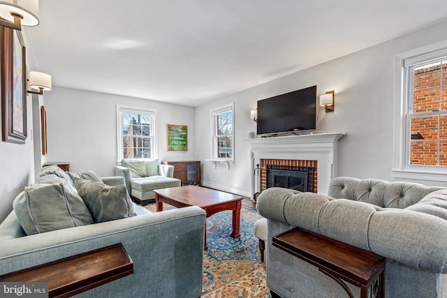 living area featuring baseboards and a fireplace