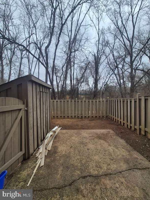 view of yard featuring a shed, an outdoor structure, and a fenced backyard