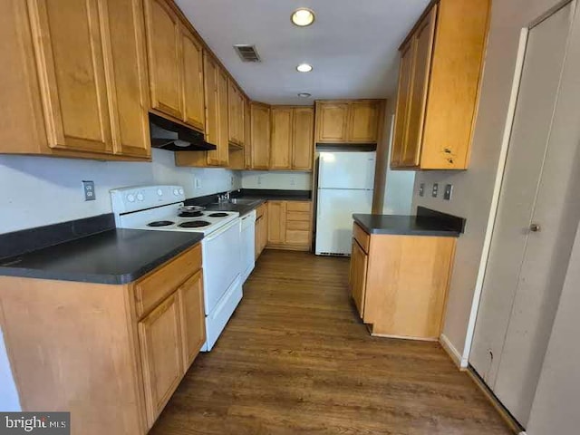 kitchen with dark countertops, white appliances, visible vents, and under cabinet range hood